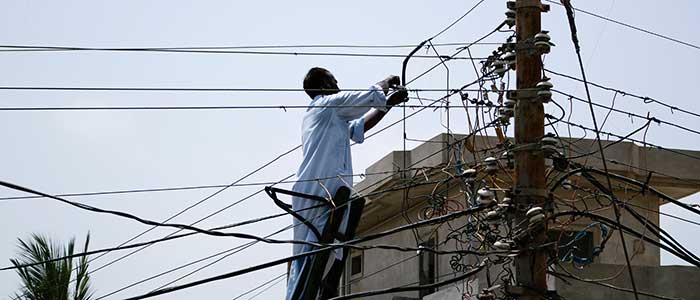 Man fixing power lines in Pakistan Man fixing power lines in Pakistan