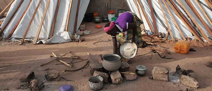 A woman cooks in a Nigerian refugee camp