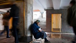 An elderly woman begs for money in a Moscow underpass.