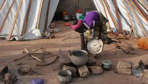 A woman cooks in a Nigerian refugee camp