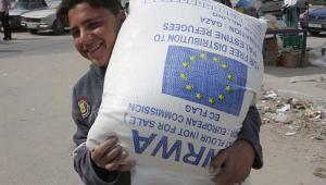 A Palestine child holding UNWRA aid. Credit: European Commission