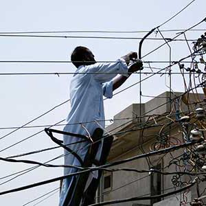 Man fixing power lines in Pakistan 