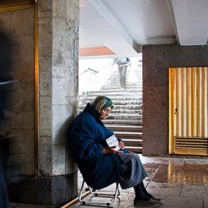 An elderly woman begs for money in a Moscow underpass.