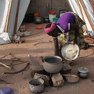 A woman cooks in a Nigerian refugee camp