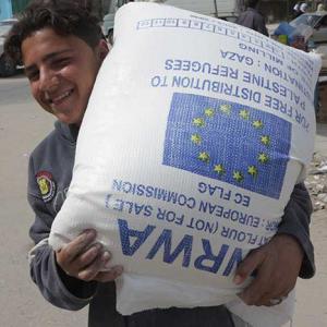 A Palestine child holding UNWRA aid. Credit: European Commission