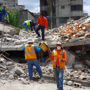 Rescue workers at the scene of a collapsed house following the earthquake in Ecuador