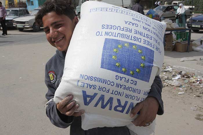A Palestine child holding UNWRA aid. Credit: European Commission