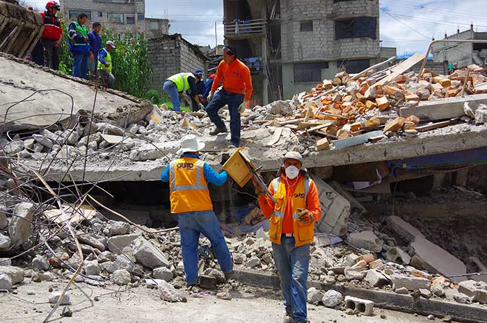 Rescue workers at the scene of a collapsed house following the earthquake in Ecuador